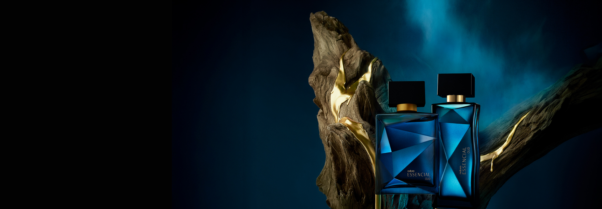 Frascos azuis de Natura Essencial Oud, masculino e feminino, sobre tronco de madeira, em fundo azul-escuro.