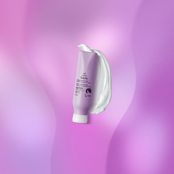 Condicionador Natura Tododia Cachos e Crespos sobre textura branca do produto, em fundo roxo.