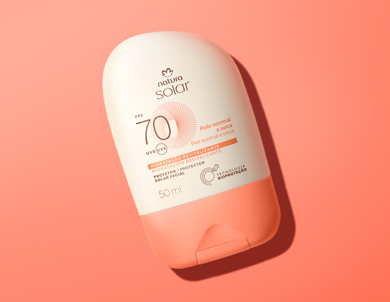 Embalagem creme com tampa laranja Natura Solar Facial FPS 70 para pele normal a seca, sobre fundo laranja.