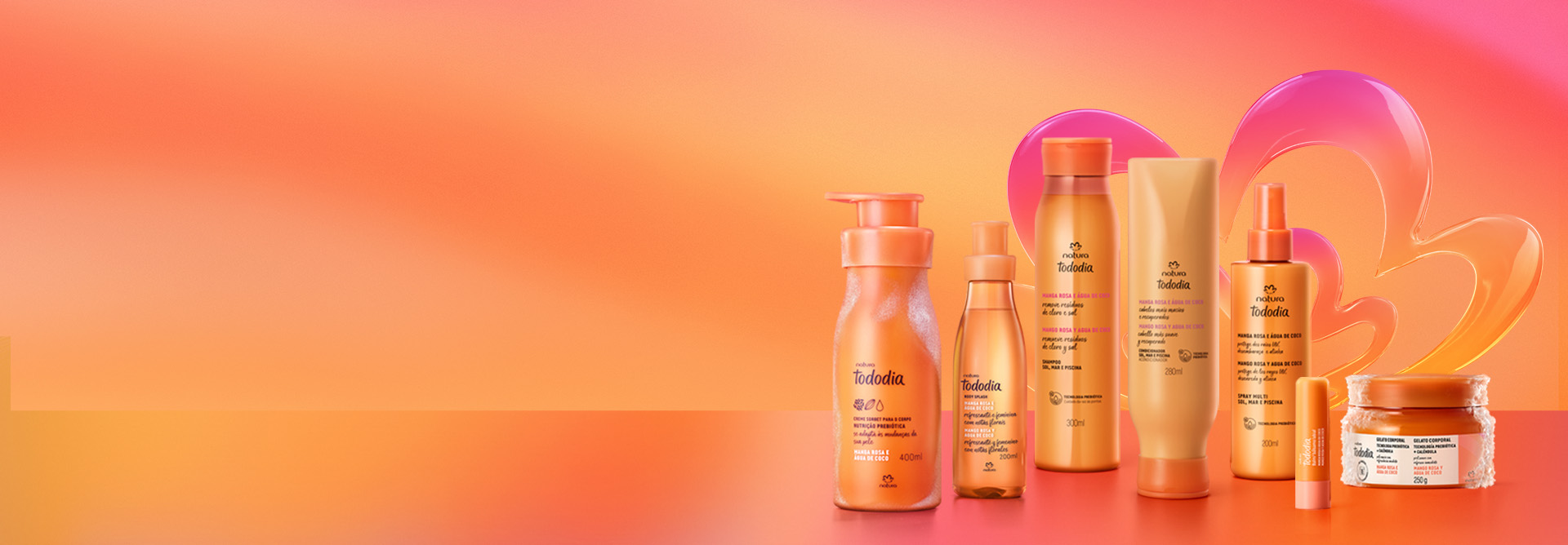 Uma coleção de sete produtos de Natura Tododia Manga Rosa e Água de Coco, incluindo hidratante, body splash, shampoo, condicionador, spray para cabelos, balm labial e gelato corporal, todos na cor laranja vibrante. No fundo, a rosácea símbolo da Natura.