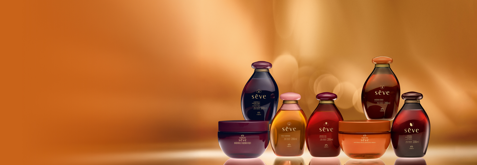 A linha Natura Sève, com Óleos Desodorantes Corporais e os novos Cremes Desodorantes Corporais Perfumados Amêndoas e Orquídea Negra e Amêndoas Doces aparecem em destaque sobre fundo em tom de dourado.