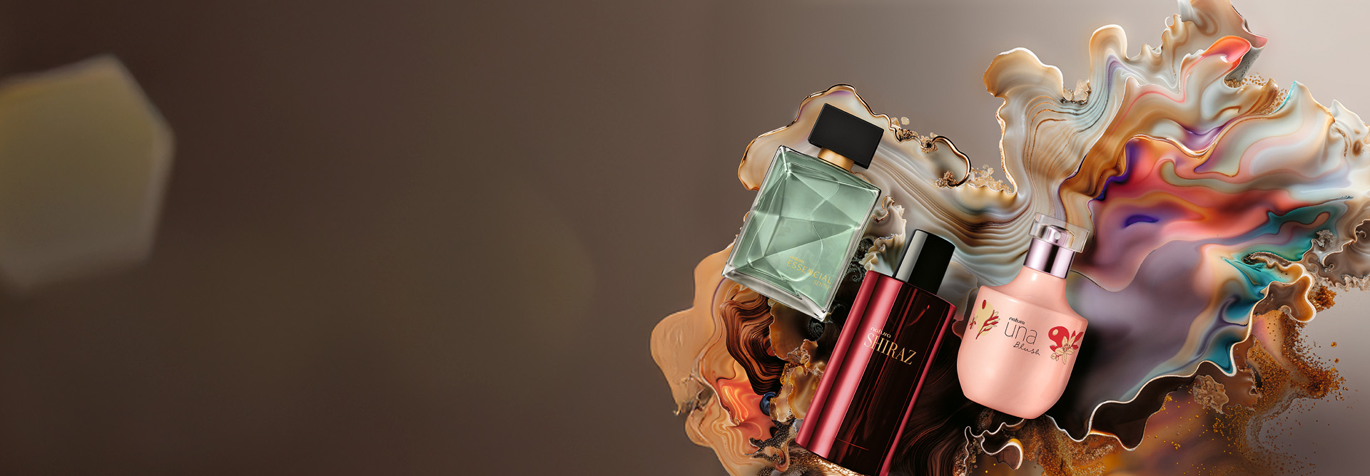 Três frascos de fragrâncias Natura, sendo Essencial Sentir Masculino, Shiraz Masculino e Una Blush. Os produtos estão sobre um fundo marmorizado em tons terrosos.