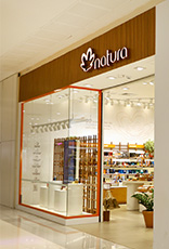 Foto de loja Natura com vitrine e entrada com produtos da marca.