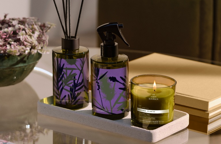 Difusor, spray de ambiente e vela aromática para fazer aromaterapia em cima de uma mesinha