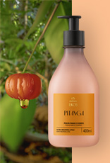 Frasco de Creme Desodorante Hidratante para o Corpo Ekos Pitanga ao lado de uma pitanga fresca em galho, sobre fundo que mistura floresta verde e lateral em tom pêssego.