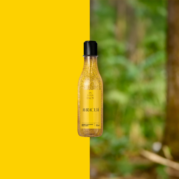 Frasco transparente do Sabonete Líquido Esfoliante Corporal Ekos Maracujá com tampa preta e rótulo amarelo ao centro. Fundo dividido entre amarelo vibrante e floresta desfocada.