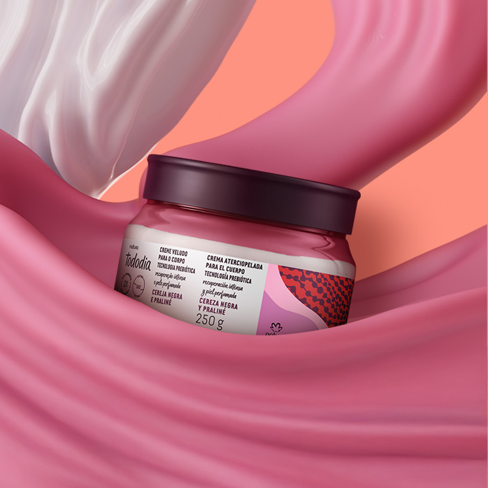 Produto Natura Tododia entre texturas cremosas nas cores creme e rosa, em fundo laranja.