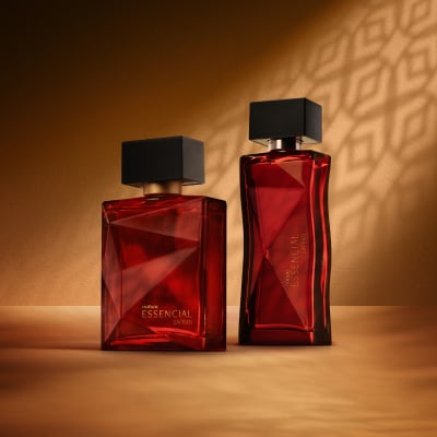Deo Parfum Essencial Safran Masculino e Deo Parfum Essencial Safran Feminino, ambos em frascos vermelhos com tampas pretas. Estão em fundo cor areia com sombra geométrica projetada.