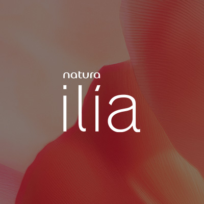 Logo de Natura Ilía, em letras brancas, destaca-se no centro da tela sobre pétalas laranjas em fundo pêssego.