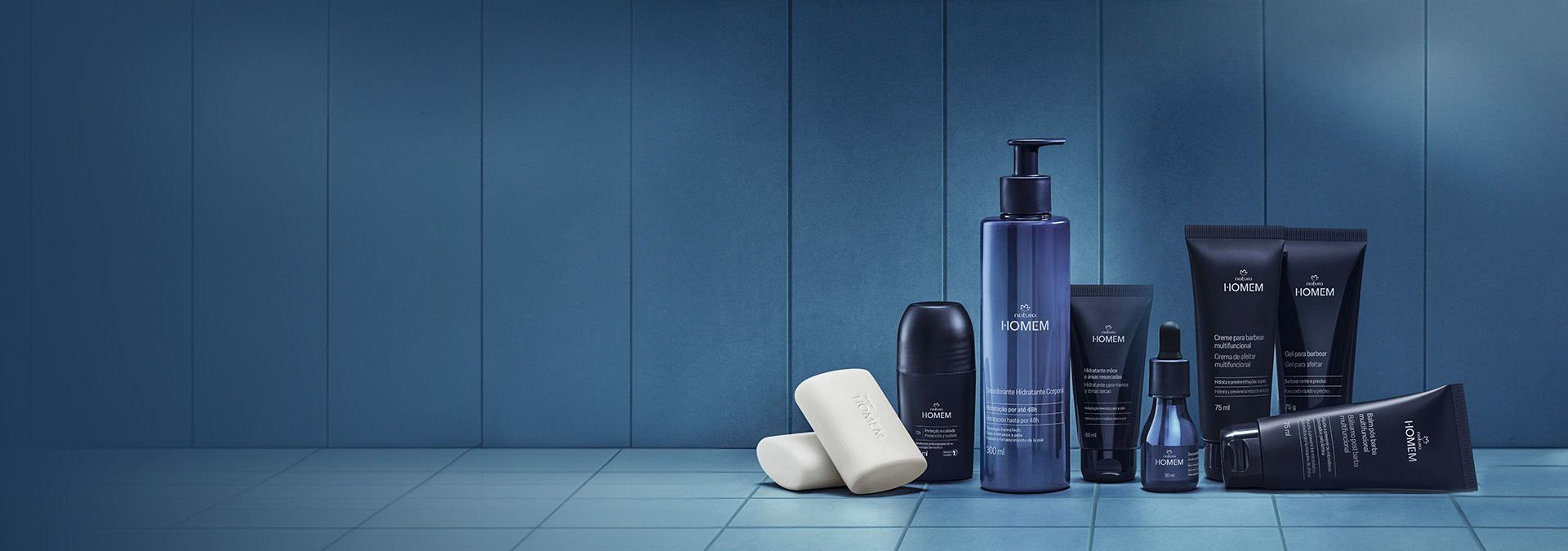 sabonete, creme para barbear, balm pós-barba e mais itens de Natura Homem sobre azulejos em um local com iluminação azul