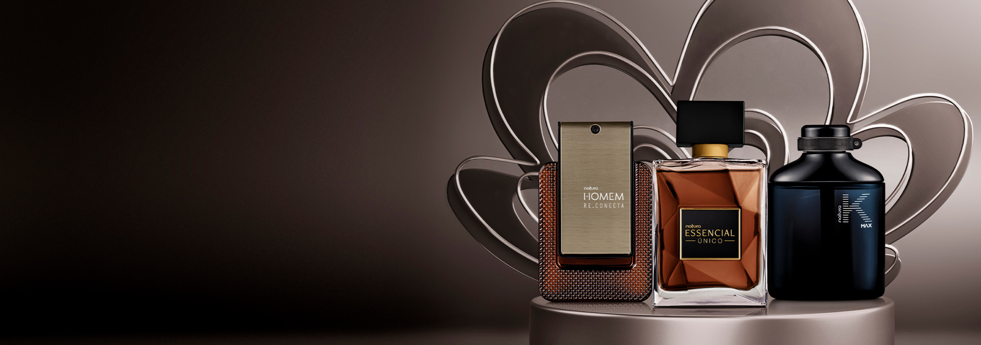 Tons de cinza ao fundo com produtos da linha Natura Homem, Essencial e KMax que representam a perfumaria masculina Natura.