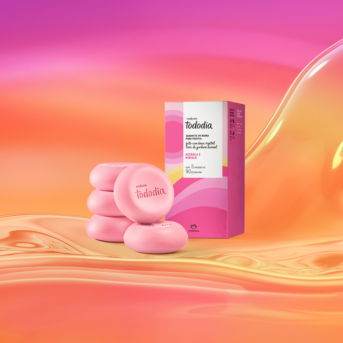 Sabonetes rosa com caixa estampada em tons rosados de Tododia Acerola e Hibisco sobre grafismo e fundo em laranja com rosa.