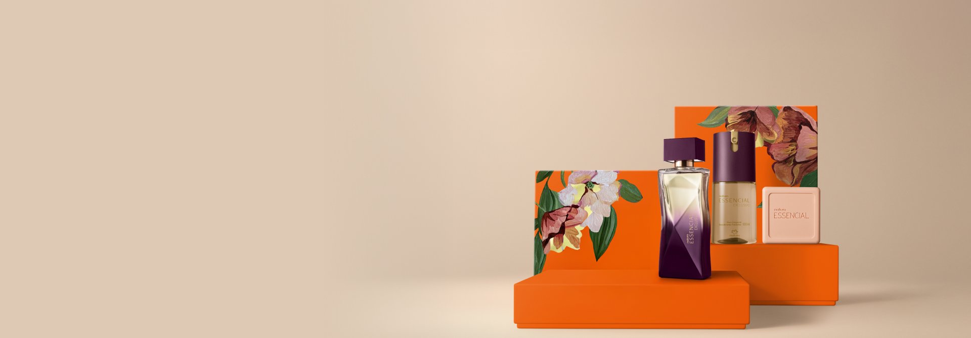 Presente Natura Essencial Exclusivo Feminino, contendo 1 Deo Parfum, 1 Desodorante Corporal e 1 Sabonete em Barra. Os itens estão sobre caixas de presentes laranja com estampa de flores em fundo bege.