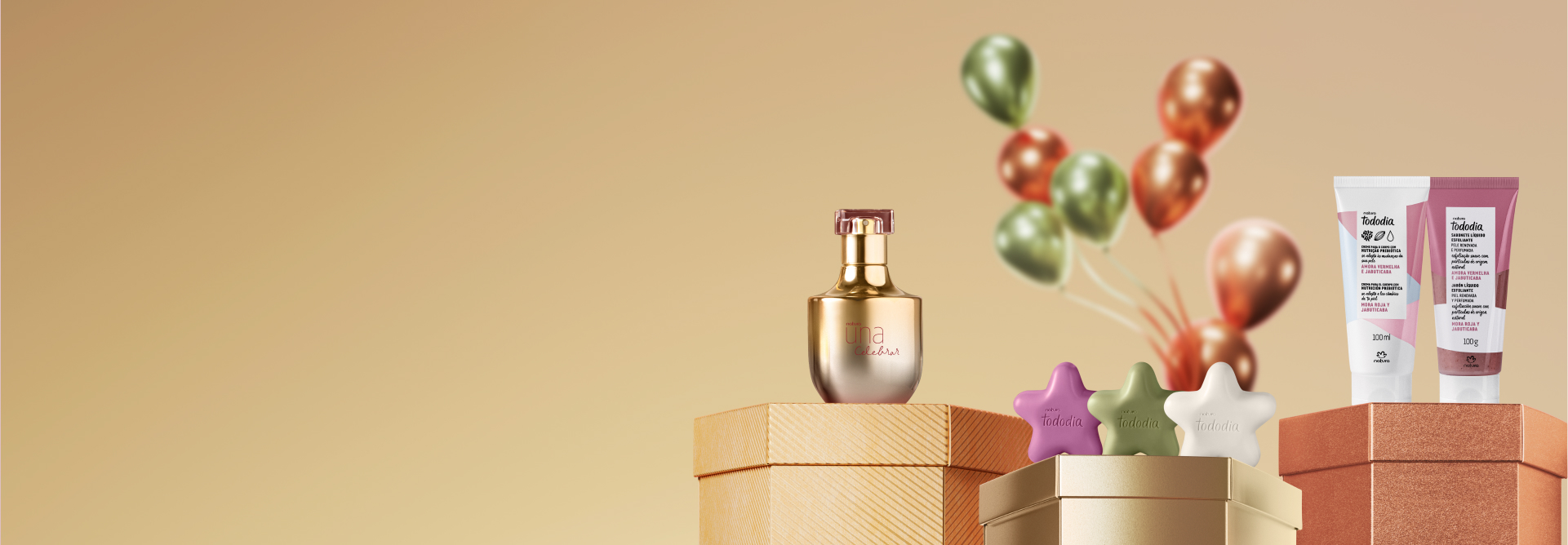 Diversos produtos Natura, Creme para o Corpo, Sabonete Líquido Esfoliante, Sabonete em Barra e Desodorante Perfume, sobre caixas de presente metalizadas. Fundo dourado com balões em verde e laranja.