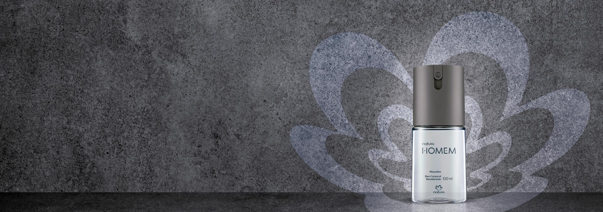 Fundo em tons de cinza escuro e ao lado direito um desodorante spray Natura Homem e rosácea ao fundo.
