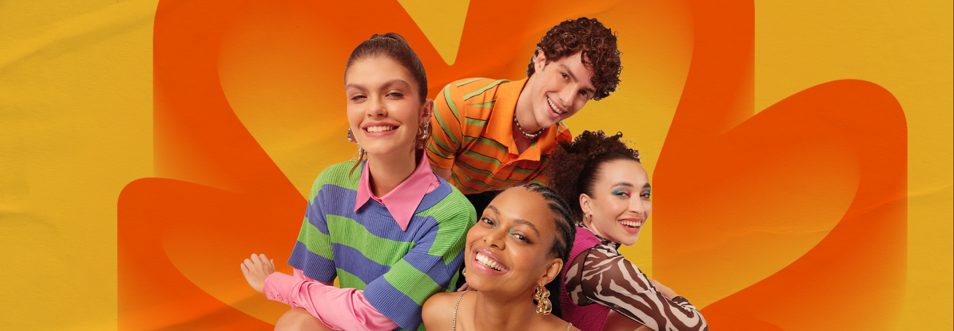 Em fundo amarelo e laranja, jovens sorriem. À esquerda, mulher de cabelos presos. Acima, homem de cabelos ondulados. À direita, mulher de cabelos cacheados presos. Ao centro, mulher negra de cabelos trançados.