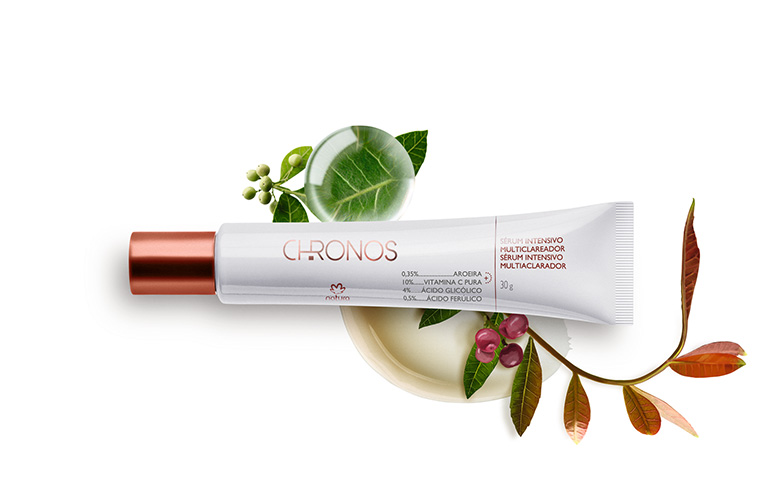 Sérum Intensivo Multiclareador Chronos Derma com vitamina C para o rosto, sobre pequenas bagas verdes e folhas.