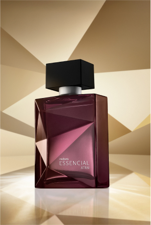 Frasco de Essencial Atrai Masculino, em tons de roxo e violeta com tampa preta, aparece em destaque em fundo dourado multifacetado, fazendo alusão ao design dos frascos de Essencial.