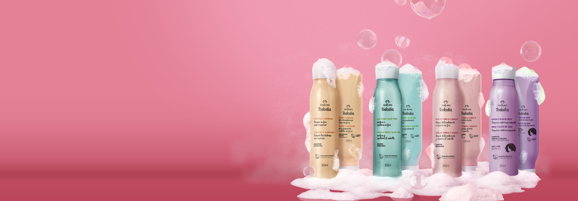 Produtos Natura Tododia Cabelos sobre espumas brancas, com bolhas de sabão, em fundo rosa.