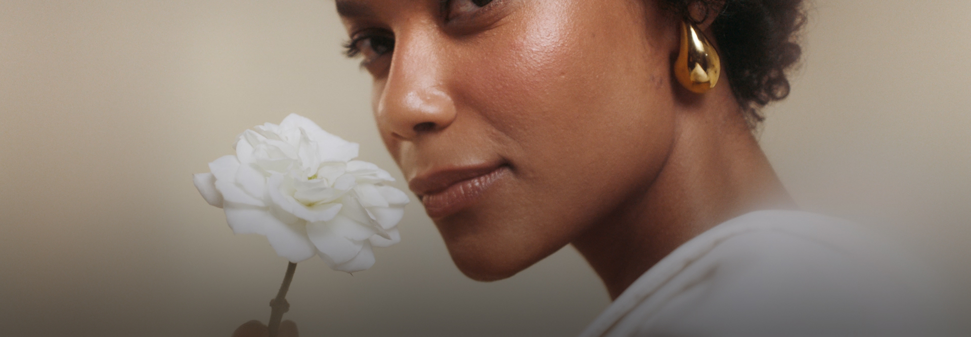 Vídeo com mulher segurando uma rosa branca e usando o Perfume Natura Aura Alba. Há também detalhes do frasco e dos ingredientes do Perfume.