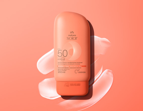 Embalagem laranja de Natura Solar Corporal FPS 50, sobre textura cremosa branca em fundo laranja.