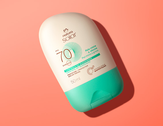 Embalagem creme com tampa verde Natura Solar Facial FPS 70 para pele mista a oleosa, sobre fundo laranja.