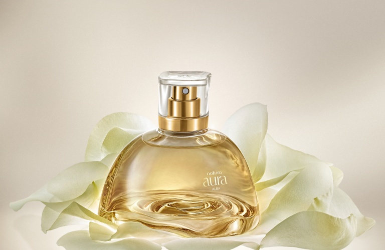 Perfume feminino marcante Aura Alba sobre pétalas brancas
