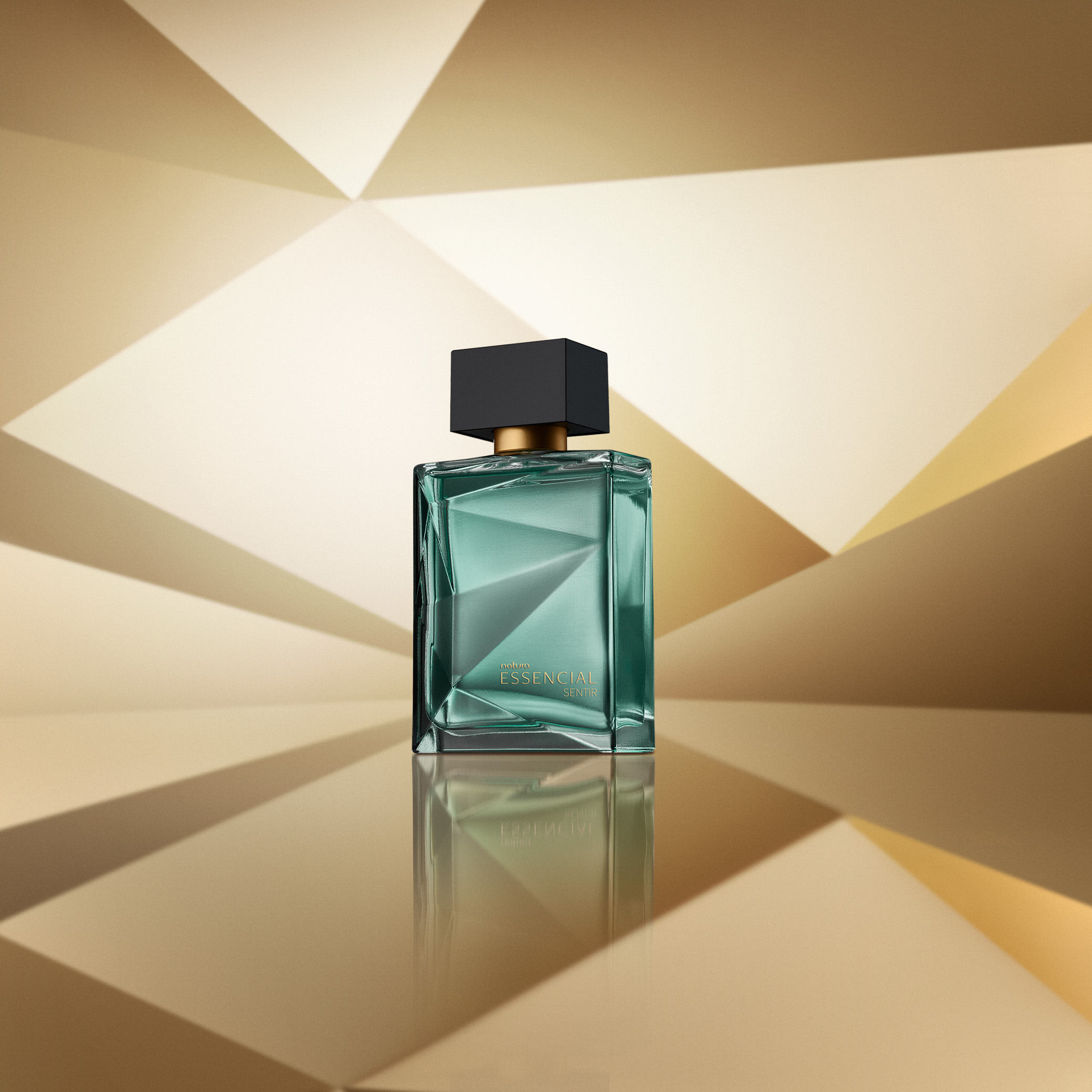 Frasco de perfume Natura Essencial Sentir em vidro transparente com tampa preta. Fundo geométrico em tons de dourado.