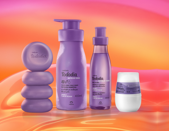 Sabonetes em Barra, Creme Sorbet para o Corpo, Body Splash e Desodorante Roll-on Tododia Amora e Flor de Pêssego, com frascos em tons de lilás, destacam-se sobre fundo fluido rosa e amarelo.