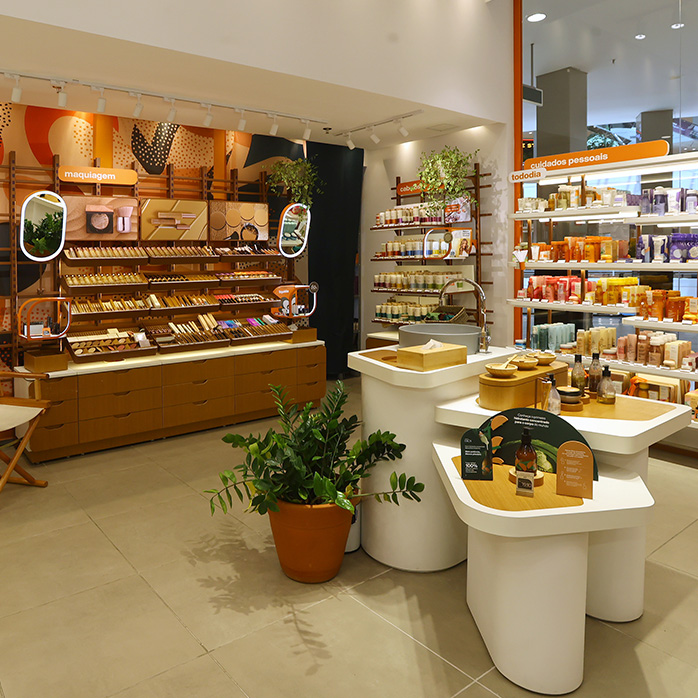 Foto do ambiente de uma loja Natura, com produtos e bancadas de experimentação.