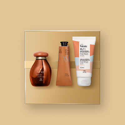 Presente Natura Queridinhos, com 1 Óleo Corporal Sève Amêndoas Doces, 1 Polpa para as Mãos Ekos Castanha e 1 Creme Nutritivo para o Corpo Tododia Macadâmia sobre caixas de presentes em fundo bege.