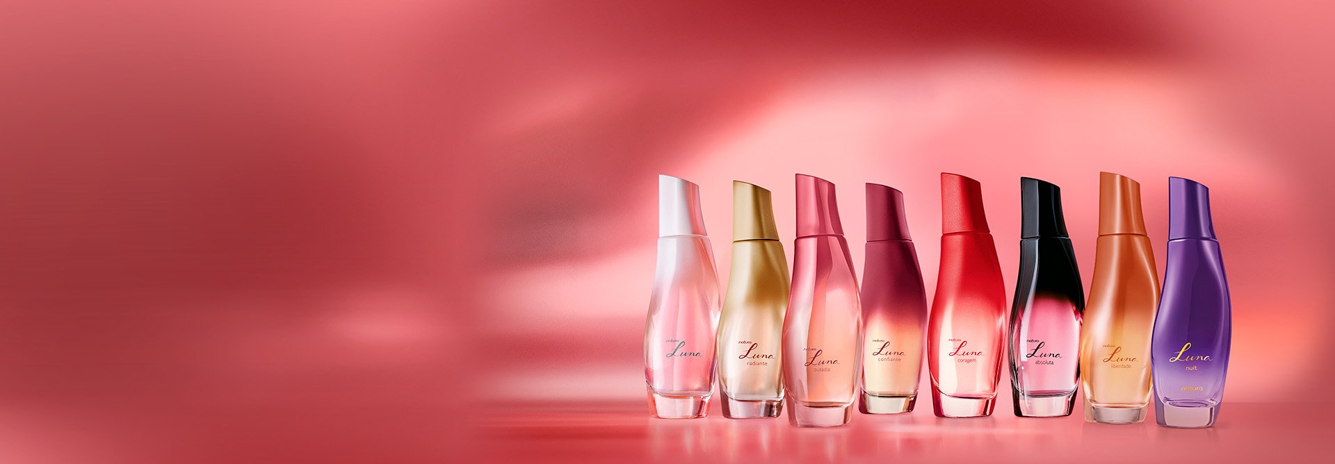 8 frascos de Desodorantes Colônias Luna: Clássico, Radiante, Ousadia, Confiante, Coragem, Absoluta, Liberdade e Nuit, em cores variadas. Eles estão alinhados sobre um fundo avermelhado.