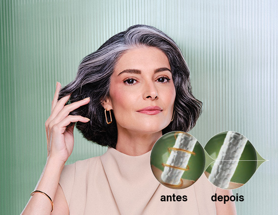 Mulher branca de cabelos médios e grisalhos usa blusa bege e brincos quadrados dourados, em fundo verde com listras verticais. À frente, representações do fio de cabelo antes e depois.