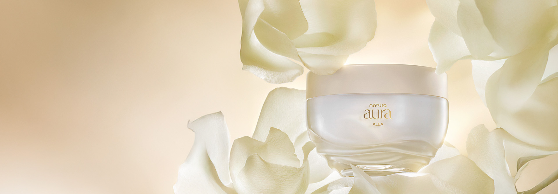Pote do Creme Corporal Aura Alba, com tampa bege e base transparente ondulada. Ele está cercado por grandes pétalas de rosas brancas, sobre um fundo bege suave.