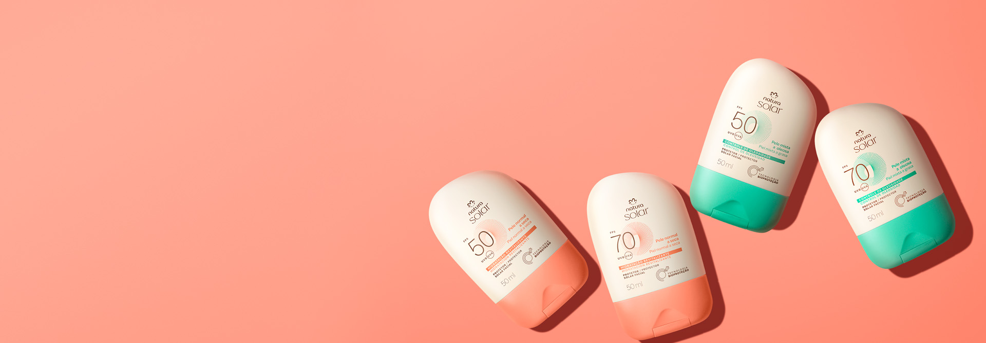 Embalagens Natura Solar Faciais FPS 50 e FPS 70, creme com laranja para pele normal e creme com verde para pele mista, com selo branco circular “Testado Dermatologicamente”, sobre fundo laranja.