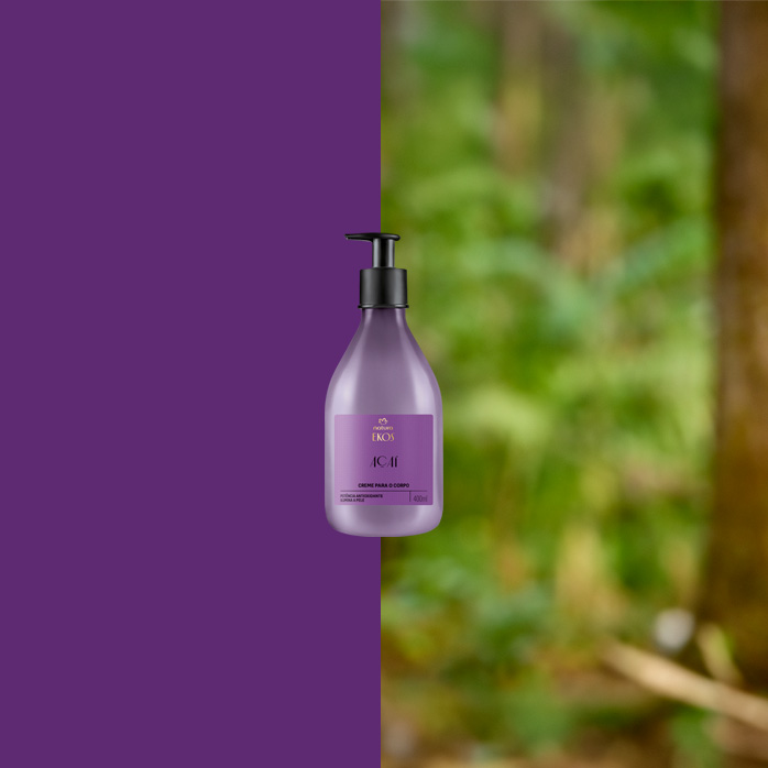 Frasco lilás do Creme para o Corpo Ekos Açaí com válvula preta ao centro. Fundo dividido entre roxo sólido e floresta desfocada, sugerindo conexão com a natureza.