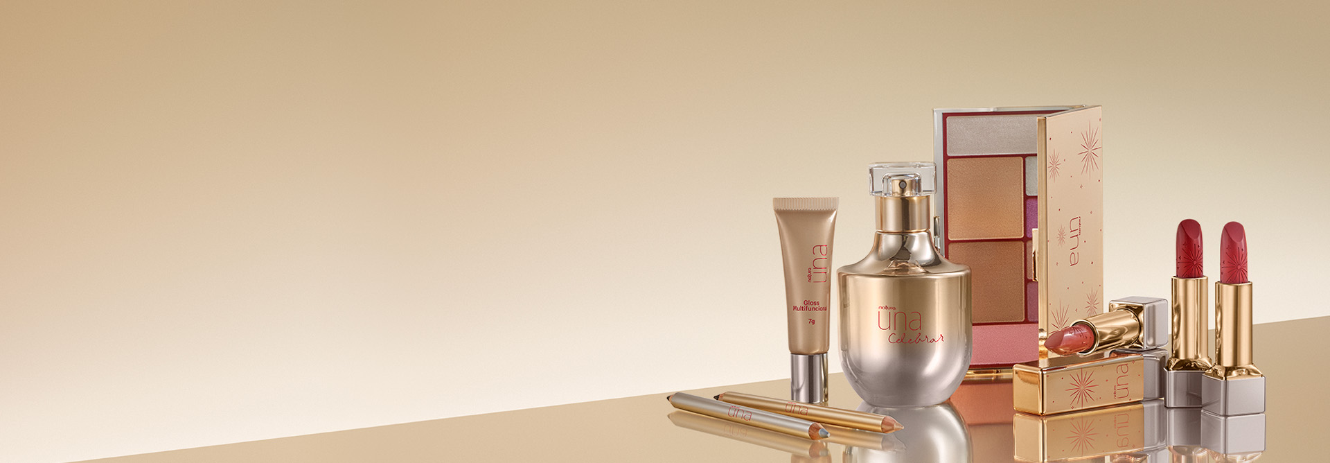 Embalagens da linha Natura Una Celebrar em dourado: 2 tons de Lápis, bisnaga de Gloss, frasco de fragrância, estojo de Paleta e 3 tonalidades de Batom em fundo amarelo-claro.