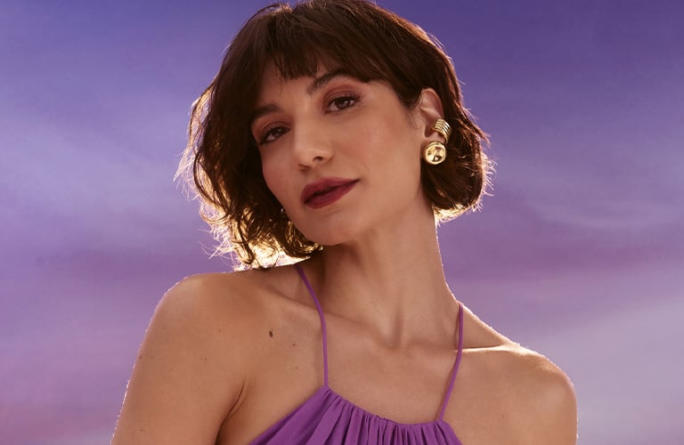 Mulher usando um corte clássico de cabelo curto feminino sobre um fundo degradê roxo