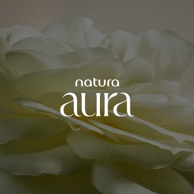 Texto em branco Natura Aura, em fundo creme com flor de pétalas brancas. 