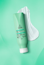 Frasco verde-claro com tampa branca do Condicionador Detox Tododia Chá de Hortelã e Gengibre. Está sobre um rastro de creme branco em fundo degradê verde.