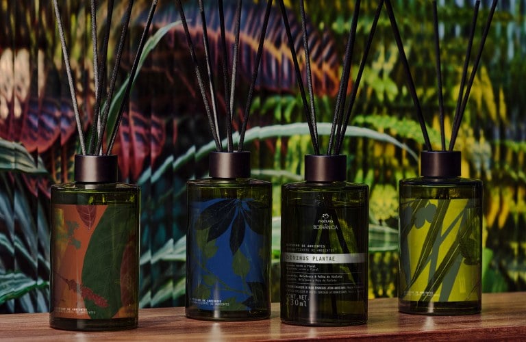 4 difusores da linha Bothânica com Palo Santo em sua fórmula em frente a uma superfície de vidro