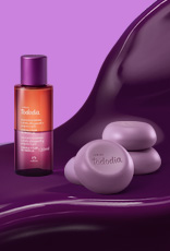 Produtos Natura Tododia Ameixa e Flor de Baunilha sobre forma orgânica na cor roxa e fundo roxo.