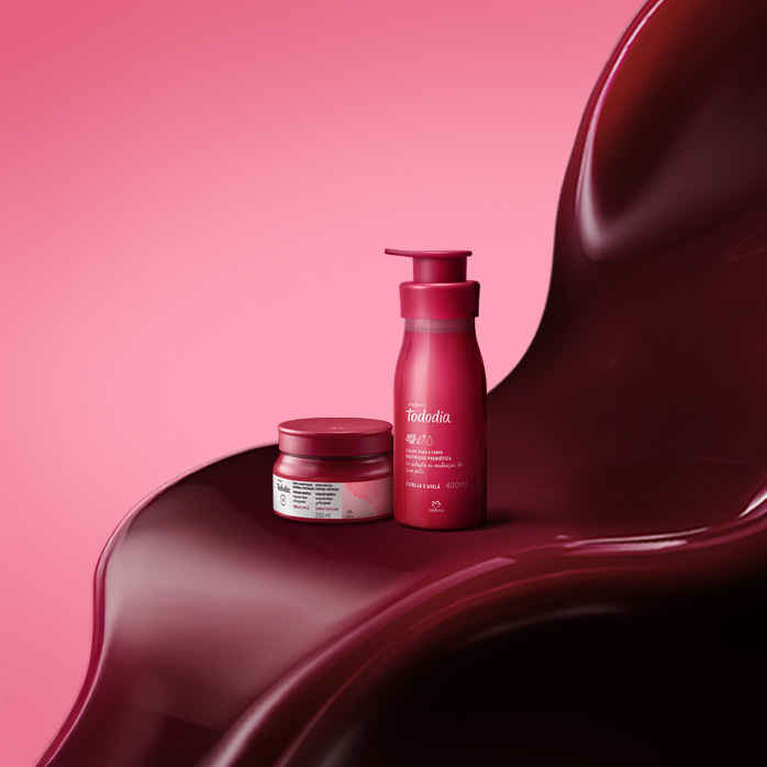 Produtos Natura Tododia Cereja e Avelã sobre formas orgânicas na cor vermelha, em fundo rosa.