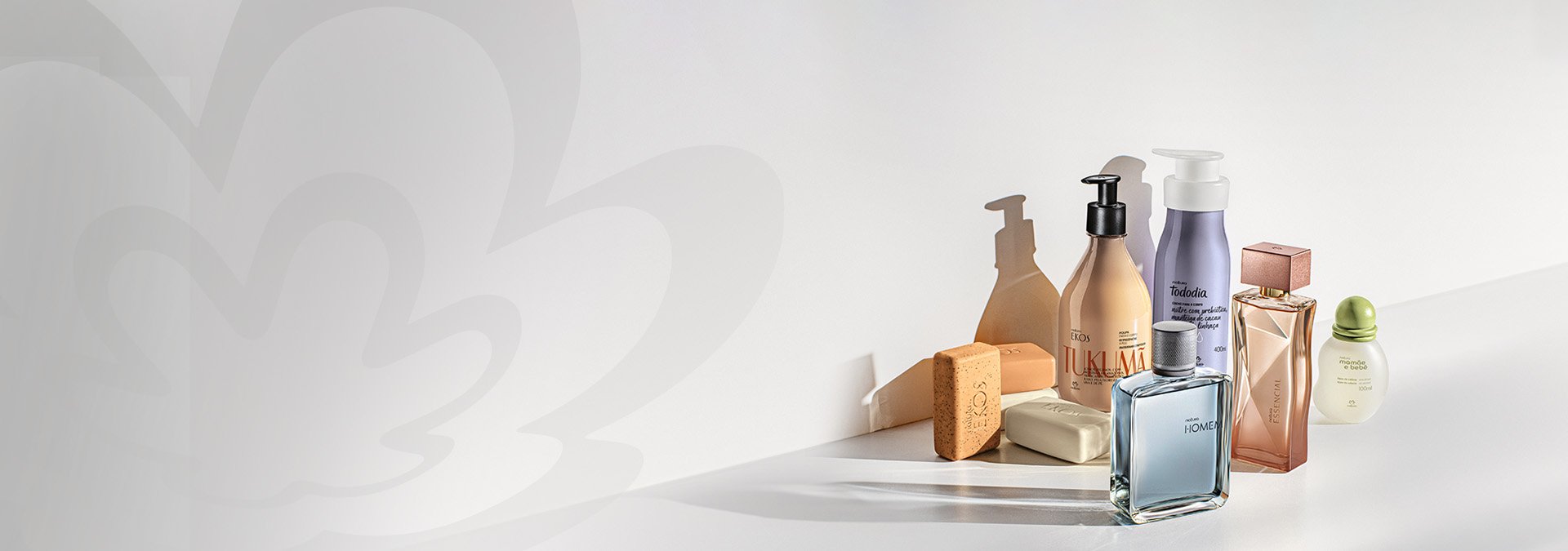 Fondo blanco con una rosácea en la parte izquierda, y a la derecha, productos de diferentes marcas de Natura como Ekos, Homem, Essencial, Tododia y Mamá y Bebé.