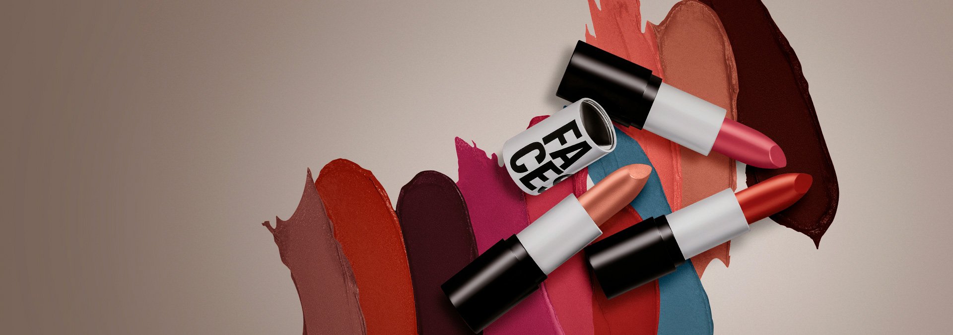 Fondo claro con tres labiales Faces abiertos en la parte derecha, mostrando la textura y el color de los labiales en el fondo.