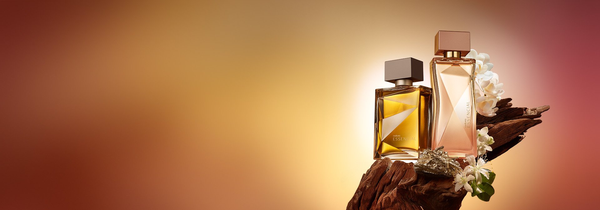 Fondo degradado dorado y marrón, perfume Natura Essencial a la derecha sobre una rama con flores blancas