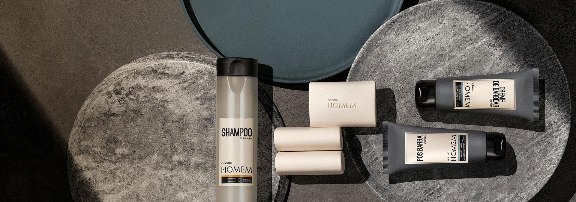 Fondo gris de piedra con productos de la línea de Natura Homem al lado derecho de la imagen