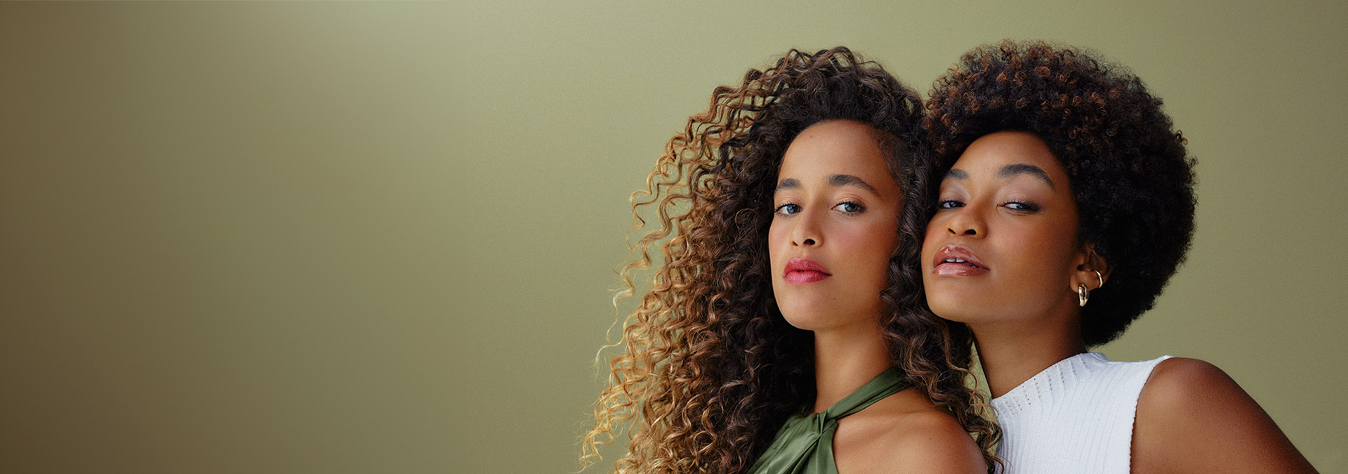 Imagen mostrando a dos mujeres negras, con diferentes tipos y colores de cabello mostrando sus cabellos.