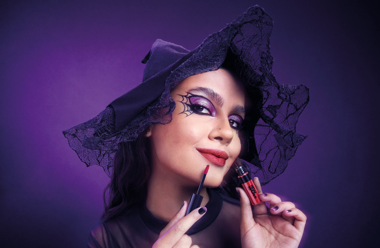 Mujer con un maquillaje de Halloween de bruja con un labial rojo Faces en las manos