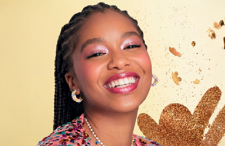 Modelo sonriendo con maquillaje con brillo